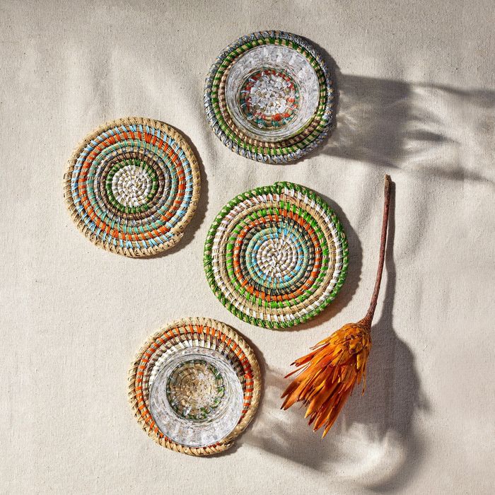 Four decorative coasters with a dried flower arrangement on the right