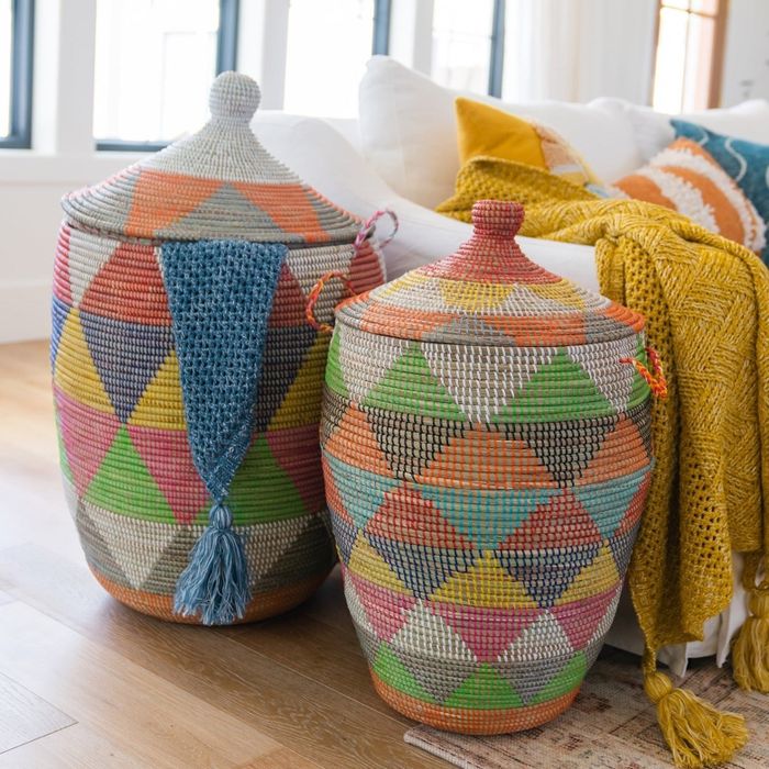Two large, intricately woven baskets in vivid colors are showcased in a cozy living room