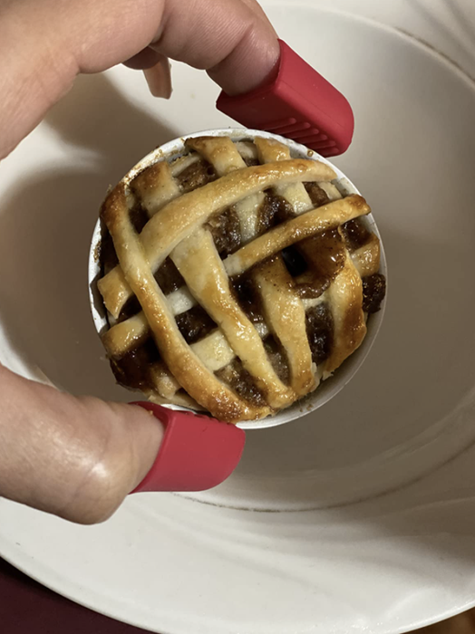 a reviewer holding a small, freshly baked pie