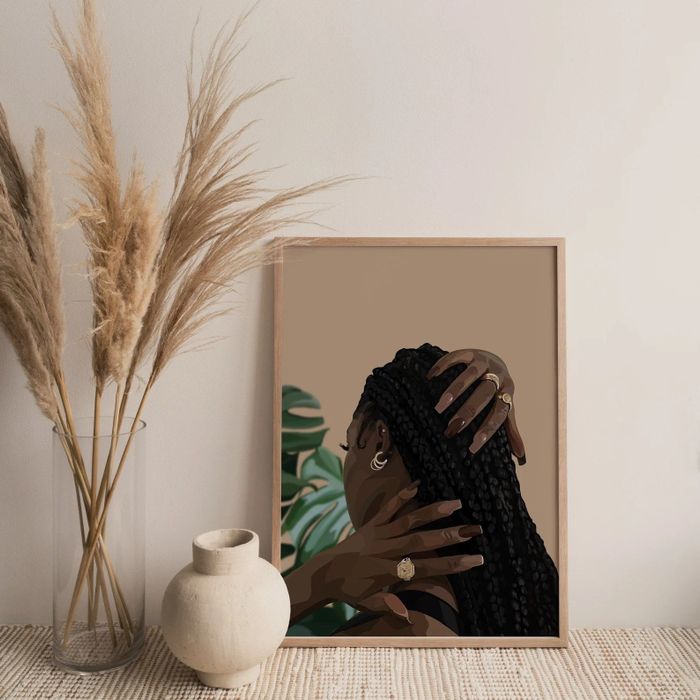 A woman gently touches a print of a hairstyle