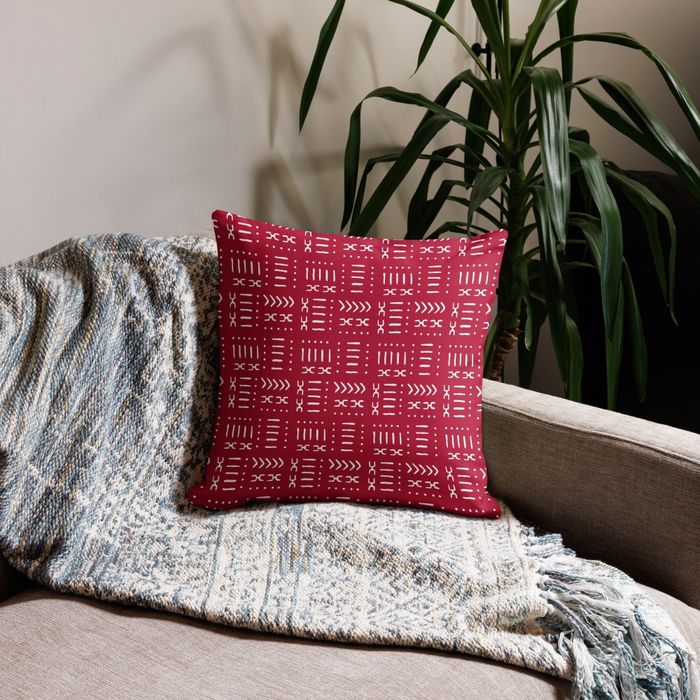 A vibrant red and white pillow rests on a sofa