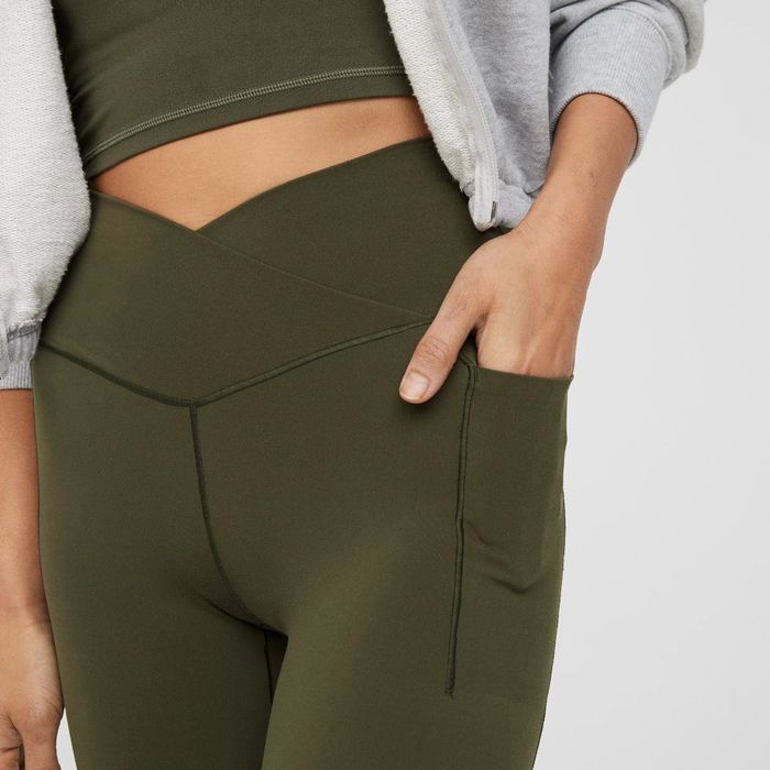 another model showcasing them in festive olive with a hand in the side pocket