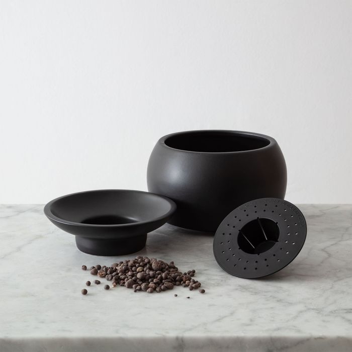 The black planter disassembled, displaying the concealed self-watering system.