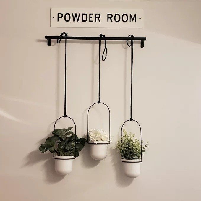 A reviewer's image showing the three white hanging planters.