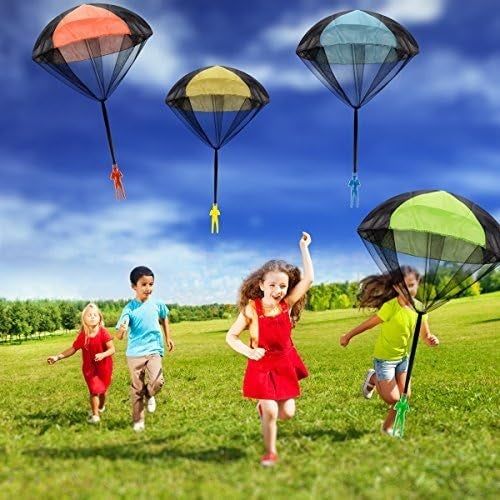 Kids running across a grassy field, gleefully playing with vibrant parachute toys soaring above them