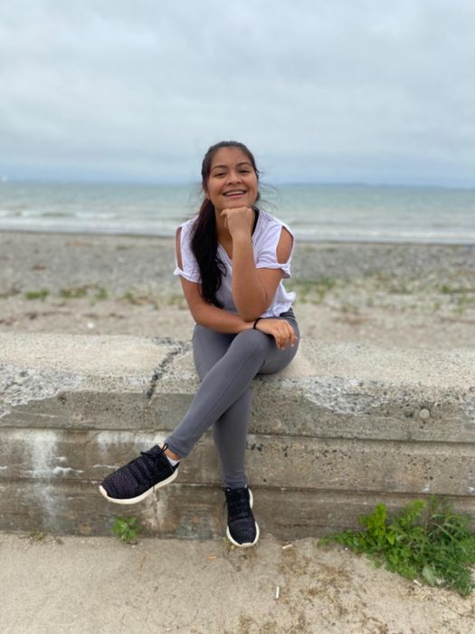 reviewer wearing gray high-waist leggings and a white workout tee with an open sleeve design