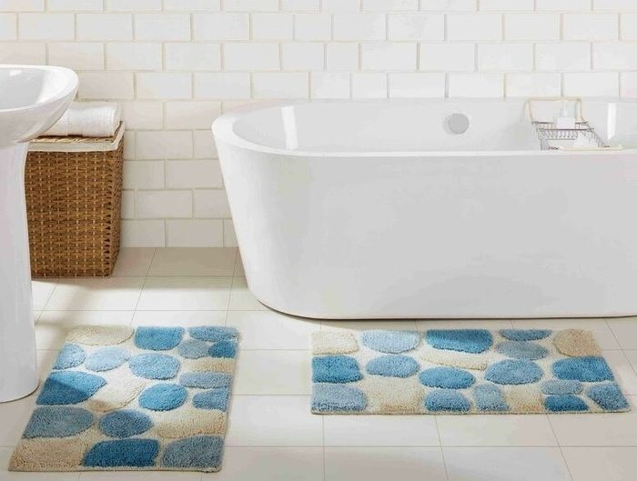 A pair of bath rugs featuring a pebble design, placed in a bathroom setting.