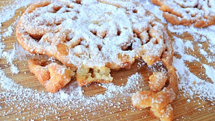 A close-up view of a broken funnel cake highlighting its unique texture.