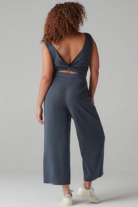 model displaying the navy jumpsuit with a twisted back design