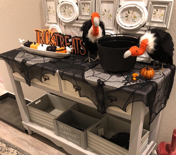 reviewer's Halloween-themed hallway table with the curtains repurposed as a table runner