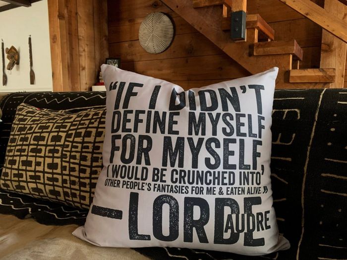A decorative pillow adorned with an empowering quote from Audre Lorde.