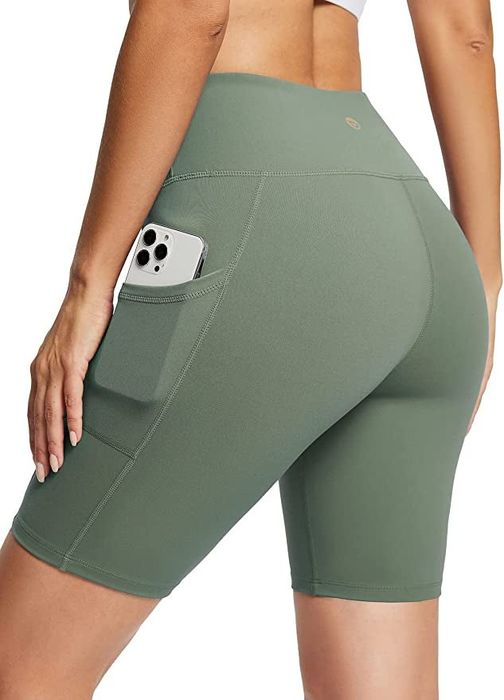 model wearing the light green shorts with a phone tucked in the pocket