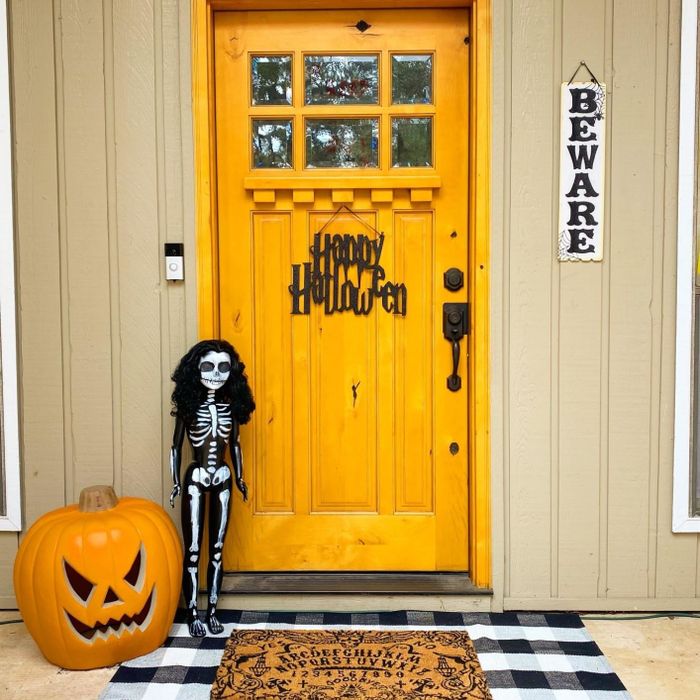 Reviewer’s doormat displayed outside a Halloween-themed front door