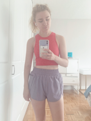 Mytour editor Emma Lord in the same style bike shorts and a pink running crop top