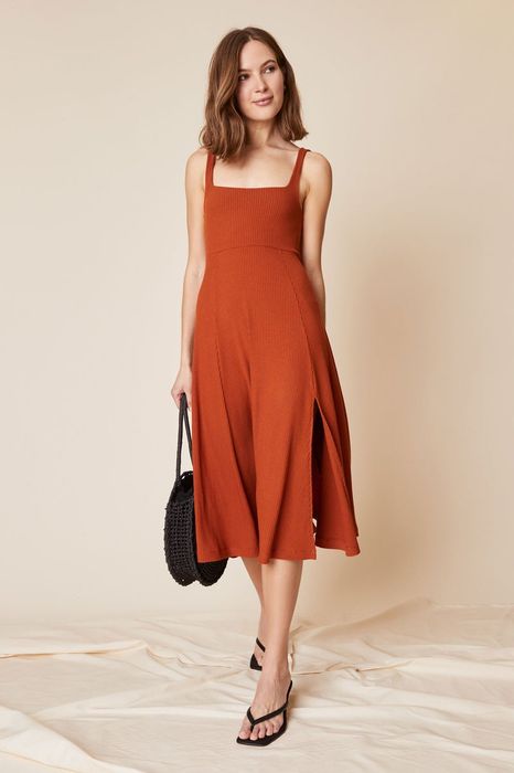 model wearing the orange dress styled with black heels