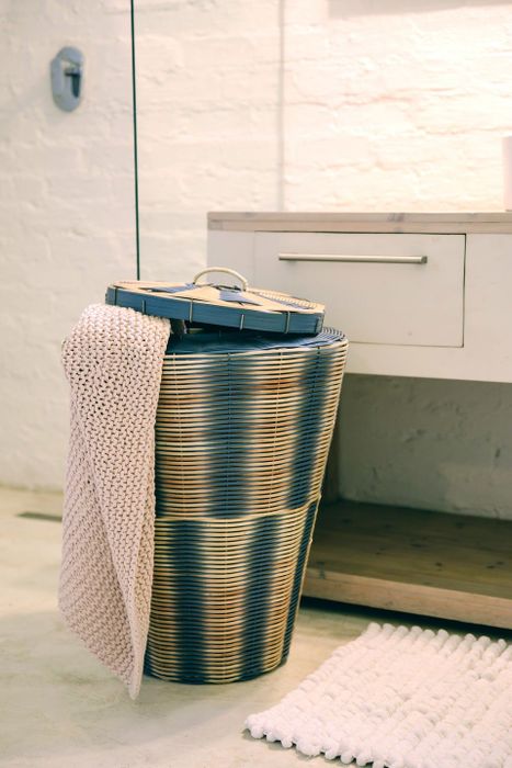 A woven basket with a towel draped over the side.