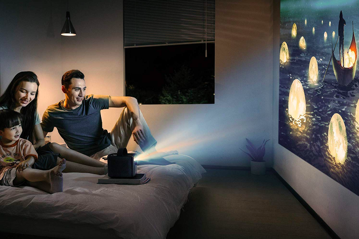 A lifestyle shot showing a projected movie on a wall, creating a cozy atmosphere.