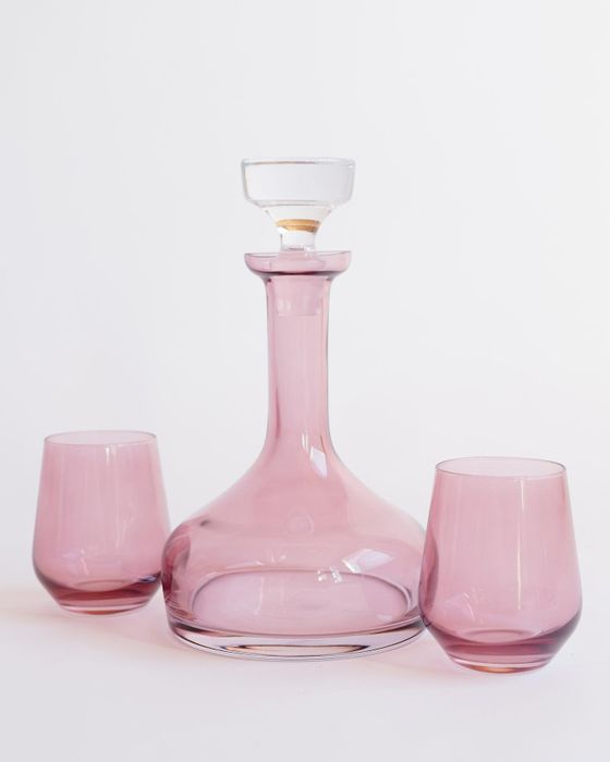 A stunning pink glass decanter paired with two matching glasses, exuding a timeless elegance.