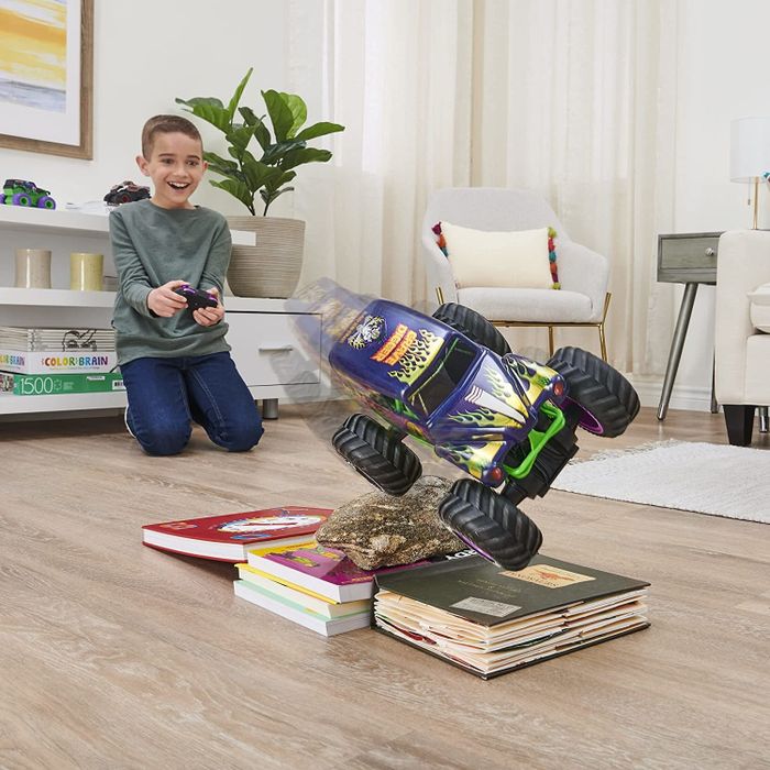 A child model playing with the remote-controlled Grave Digger truck.