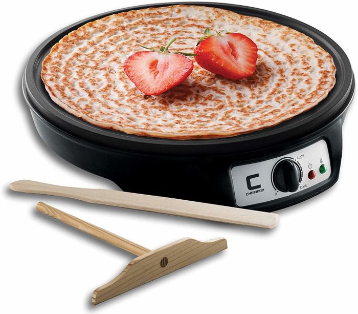 A round griddle accompanied by two wooden utensils.