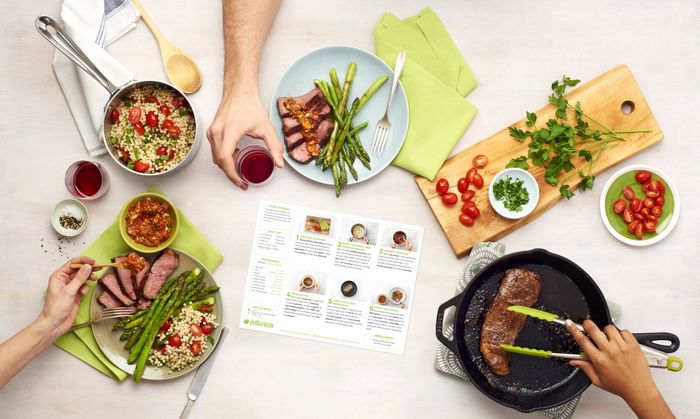 The recipe card and the perfectly cooked steak and couscous dinner on the plate.