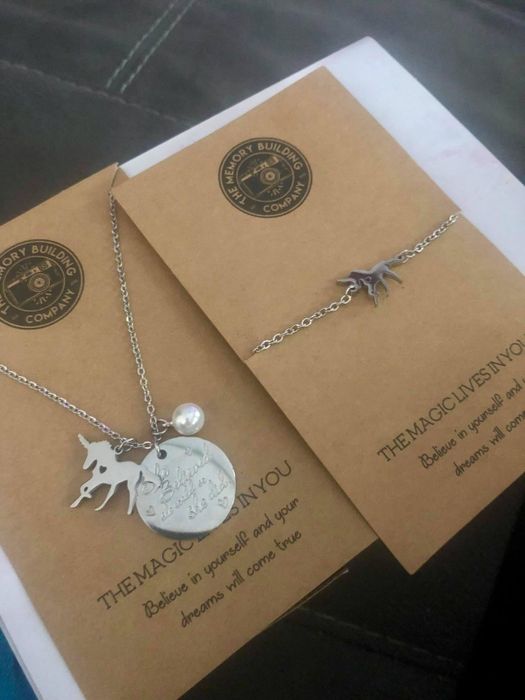 A reviewer's photo showcasing the two unicorn necklaces
