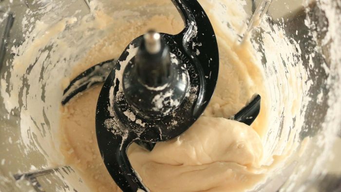 Tapioca dough resting inside the bowl of a food processor.