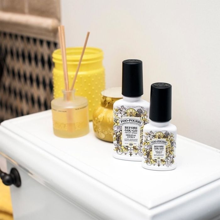 Two bottles of original citrus Poo-Pourri next to the toilet