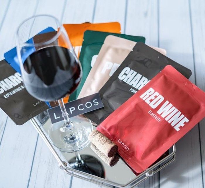 A collection of sheet masks alongside a glass of wine, perfect for a relaxing night in.