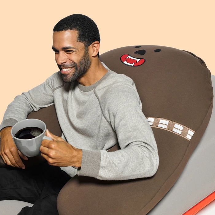 An adult model sitting on the pillow for size reference.