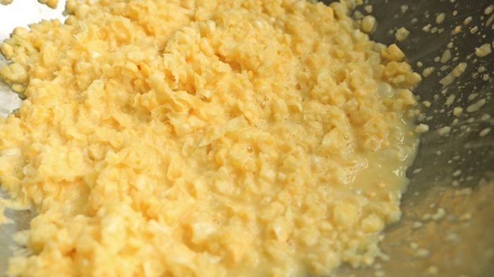 A bowl filled with mashed corn kernels.