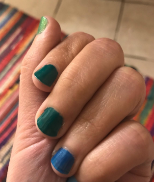 A reviewer's photo showing nails painted in vibrant blue and green colors.