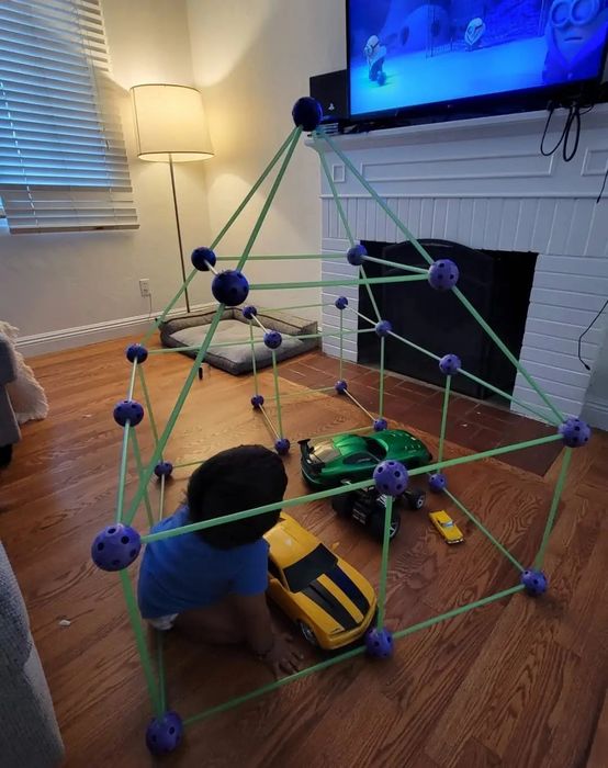 A reviewer's photo capturing their child relaxing inside a fort they constructed.