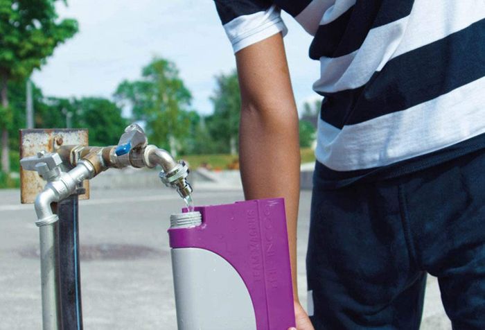 A model filling a purple and gray water blaster.