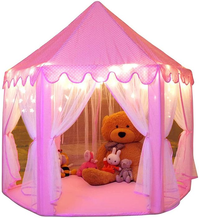 A photo of the pink tent with lights, surrounded by plush stuffed animals inside.
