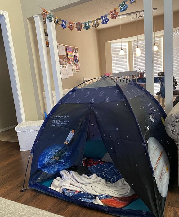 A reviewer's photo of a tent set up indoors.