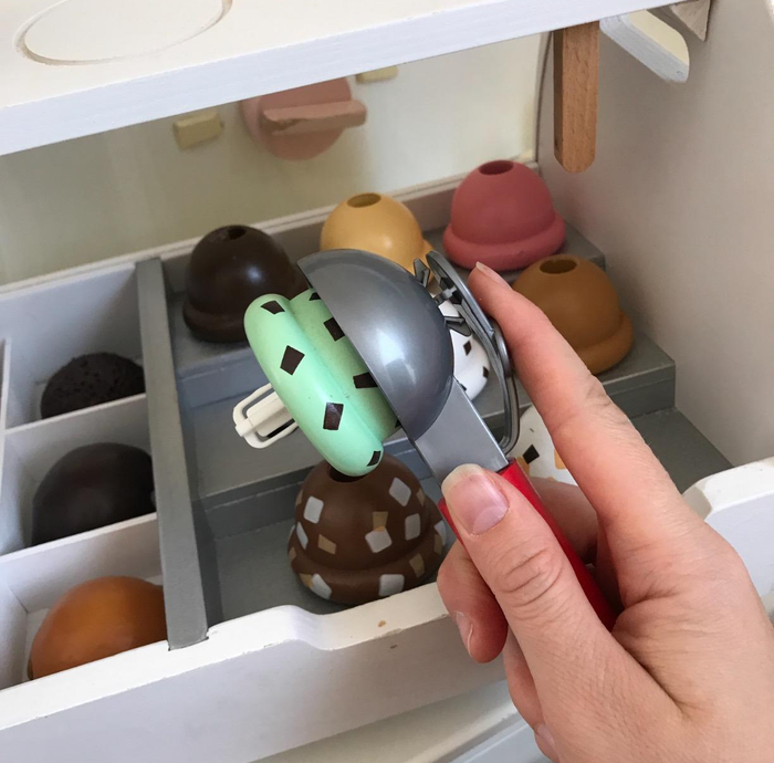 A photo from the reviewer holding a toy scoop with pretend ice cream on it