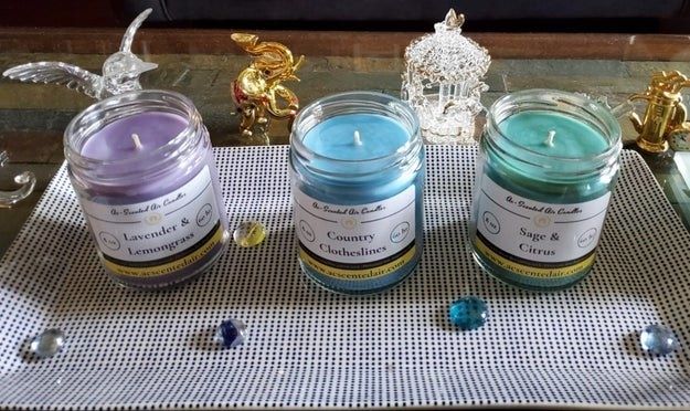 three glass candles in shades of purple, blue, and green