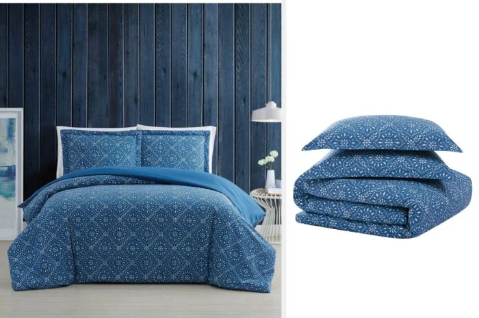 Blue rhombus-patterned duvet with matching pillowcases displayed against a navy blue wooden wall, folded neatly beneath a matching pillow on a white backdrop.