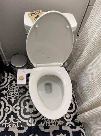 A view of the bamboo bidet attachment with the toilet seat in the down position.