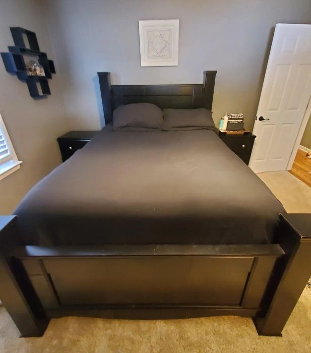 Reviewer image showcasing the duvet cover in black with matching pillowcases, placed on a dark wood bed frame.