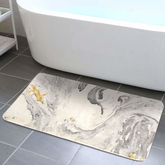 A lifestyle image showing the bath mat placed in front of a bathtub.