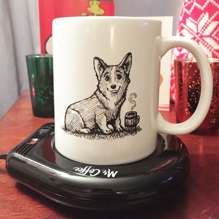 a corgi-illustrated mug placed on a sleek black Mr. Coffee mug warmer