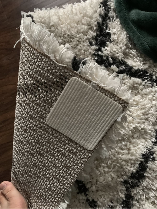 A review photo showing the rug grippers attached to the back of a rug.