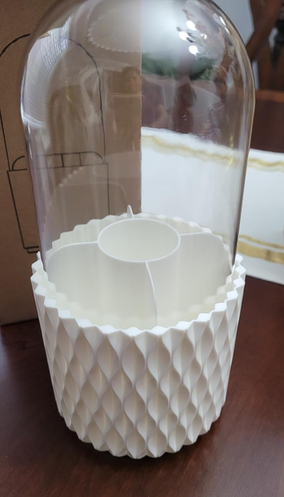 A chic makeup brush cloche featuring a white textured base and a delicate glass dome.