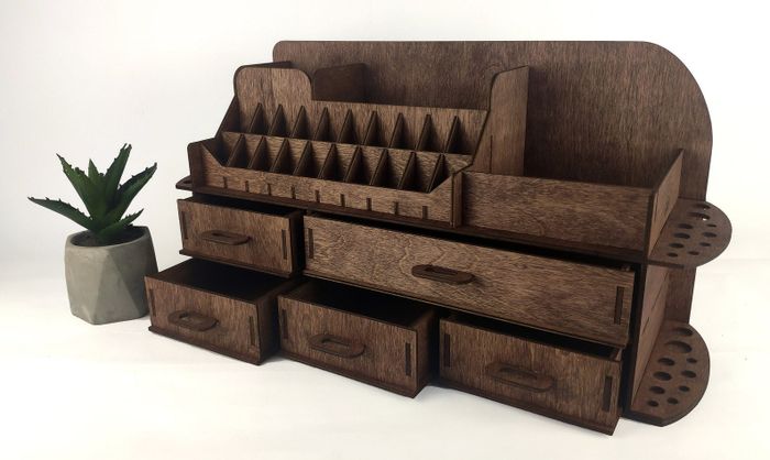 A wooden organizer featuring multiple compartments and drawers, placed next to a small potted plant, ideal for both home and office use.