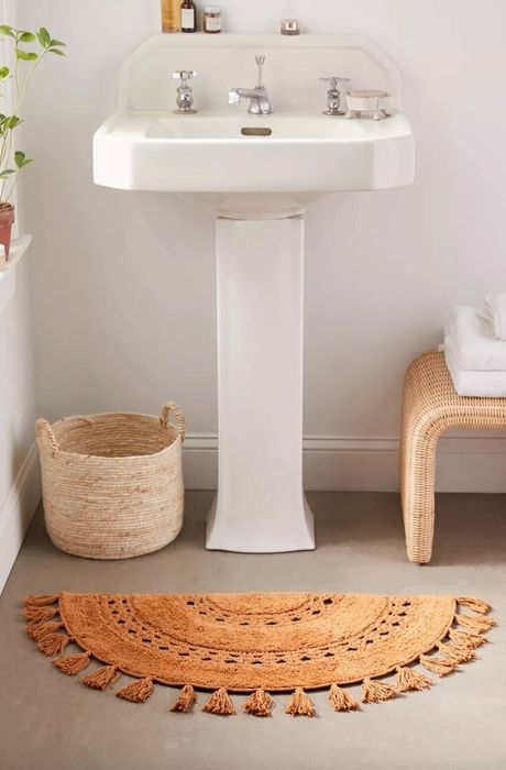 the dark yellow bathmat positioned in front of a decorated sink space