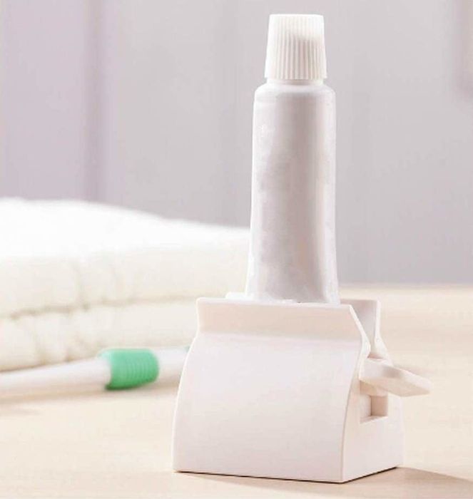 A toothpaste tube standing vertically in a white stand.