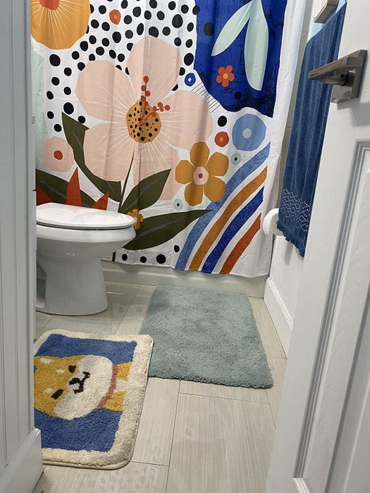 A reviewer image showing the corgi bath mat placed in front of a bathroom sink.