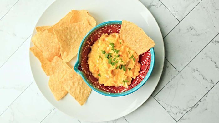 A plate of crispy tortilla chips sits next to a bowl filled with soft scrambled eggs.